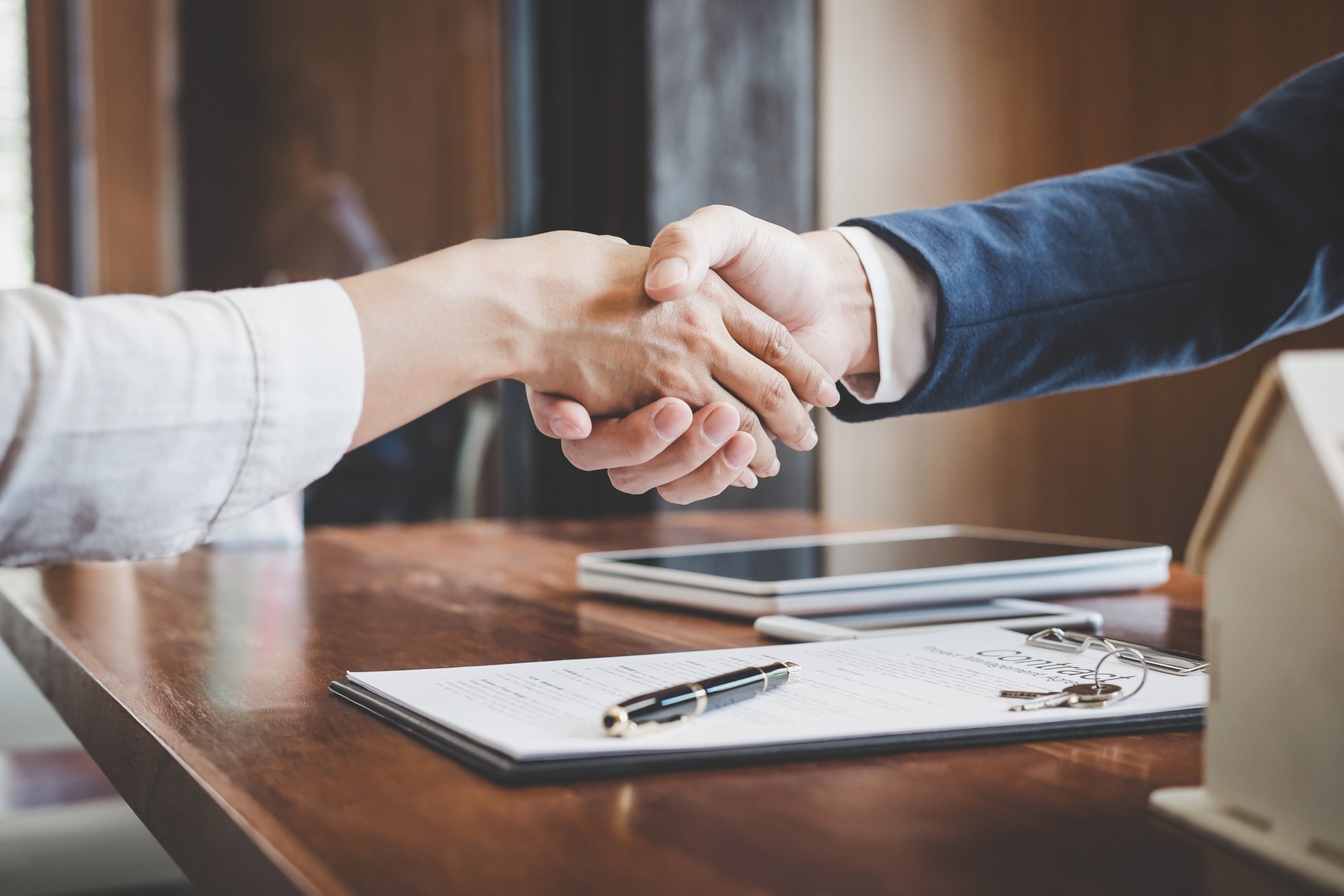 Real estate agent and customers shaking hands together celebrating finished contract after about home insurance and investment loan, handshake and successful deal